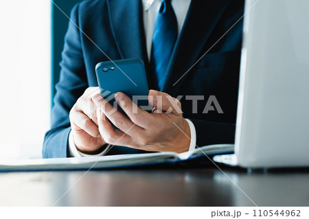 スマホでメールを送るビジネスマンの手元 スマホでメールを送るビジネスマンの手元 110544962