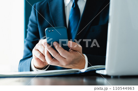 スマホでメールを送るビジネスマンの手元 110544963