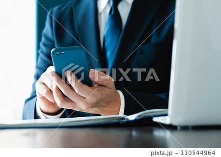 スマホでメールを送るビジネスマンの手元 スマホでメールを送るビジネスマンの手元 110544964