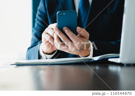 スマホでメールを送るビジネスマンの手元 110544970