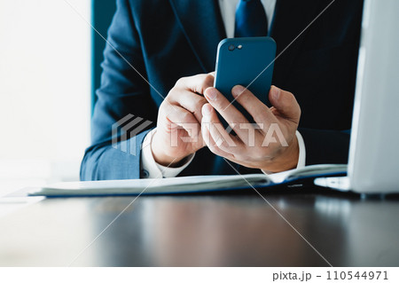 スマホでメールを送るビジネスマンの手元 110544971