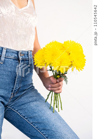 Anonymous woman holding yellow flowers. 110545642