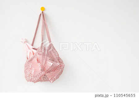 Paper Christmas tree in reusable mesh shopping bag hanging on hook. Paper Christmas tree in reusable mesh shopping bag hanging on hook. 110545655