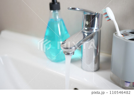 water pouring from a faucet tap slow motion  110546482