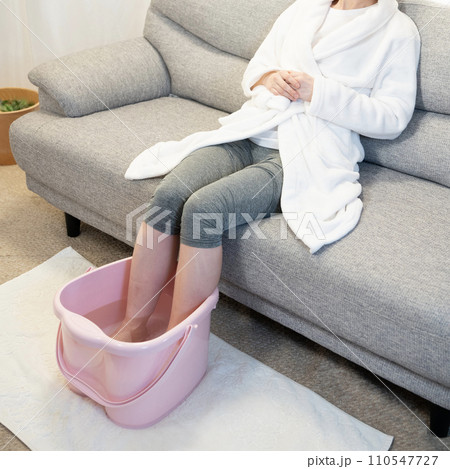 ソファーに座って足湯を使う女性の足元 ソファーに座って足湯を使う女性の足元 110547727