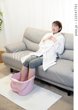 ソファーに座って足湯を使う女性 ソファーに座って足湯を使う女性 110547781