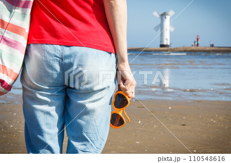 Woman with sunglasses in shape of heart on west breakwater. Windmill Stawa Mlyny in Swinoujscie. 110548616