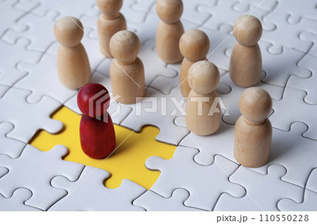 Wooden dolls on top of jigsaw with missing jigsaw puzzle. Hiring and employment concept 110550228