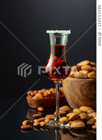 Italian liqueur Amaretto with almonds nuts on a black background. 110553590
