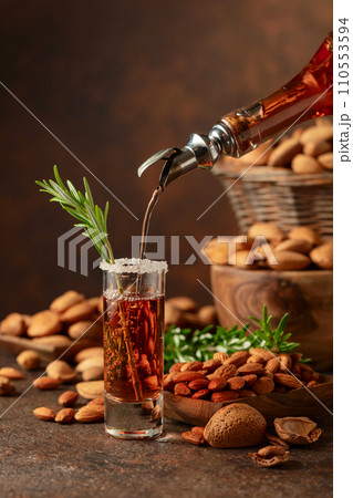 Italian liqueur Amaretto with almonds nuts on a wintage table. Italian liqueur Amaretto with almonds nuts on a wintage table. 110553594