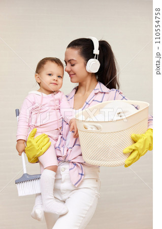 happy mother housewife is holding cute baby girl and basket with laundry , Happy family 110554758
