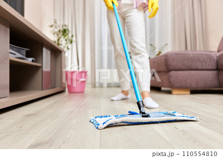 young woman cleaning and mopping floor at living room, daily housekeeping , close-up young woman cleaning and mopping floor at living room, daily housekeeping , close-up 110554810