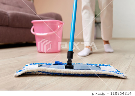 caucasian woman cleaning and mopping floor at living room, daily housekeeping , close-up 110554814