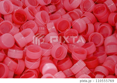 The pile of red plastic caps of drinking water bottles. 110555769