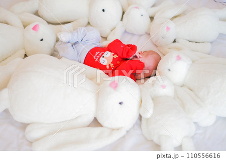 Sleeping infant baby boy with many dolls rabbit on white blanket newborn concept 110556616
