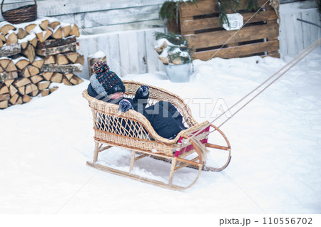 A father takes his son for a ride in the woods in winter 110556702