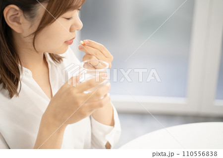 薬を飲む女性 110556838