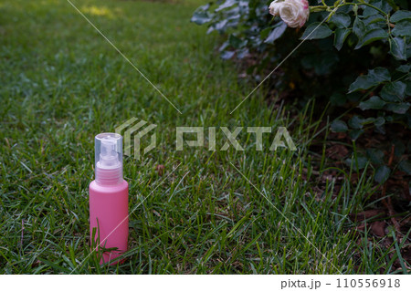 Pink cosmetic bottle on nature background staying in the garden 110556918