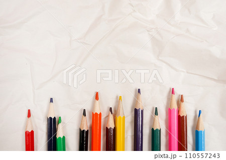 Colored Pencils for School on Crumpled white paper background Colored Pencils for School on Crumpled white paper background 110557243