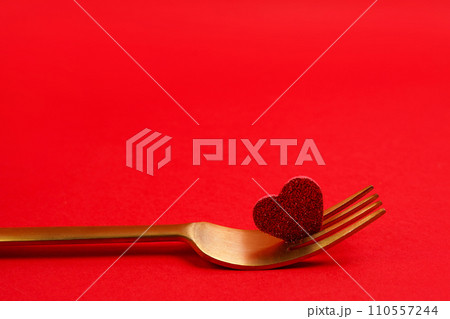 Golden Fork and a heart on red background. Holiday menu for Valentines Day Golden Fork and a heart on red background. Holiday menu for Valentines Day 110557244