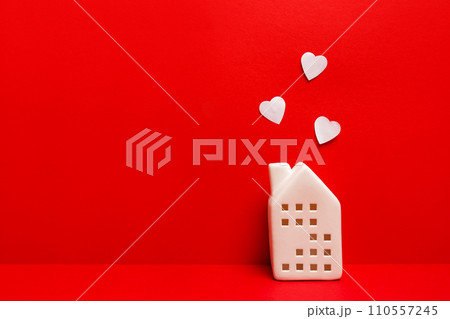 Toy house with white hearts on red background with copy space 110557245