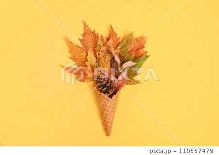 Ice cream cone with autumn leaves on light background, copy space, flat lay. Colorful bright creative layout 110557479