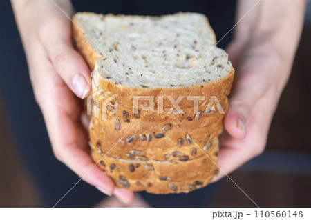 Woman's hands holding slices of bread close-up. The process of preparing fresh sandwiches. 110560148
