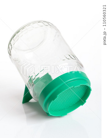 Germination glass with green sieve top. Sprouting jar for sprouting seeds, and for growing shoots on the windowsill. Easy sprouting without soil and on pure water basis. Close-up, side view. Photo. 110560321