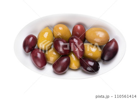 Kalamata and green olives with pit, pickled whole, large Greek table olives, in a white oval bowl. Purple fruits picked when ripe, and green olives picked while still unripe, both preserved in brine. Kalamata and green olives with pit, pickled whole, large Greek table olives, in a white oval bowl. Purple fruits picked when ripe, and green olives picked while still unripe, both preserved in brine. 110561414