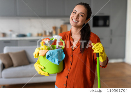 Happy woman with a bucket of cleaning products and mop 110561704