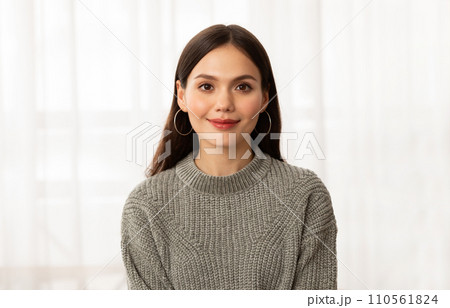 Portrait of young pretty brunette lady posing next to window 110561824