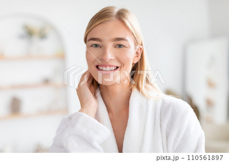 pretty blonde lady in white bathrobe posing at bathroom indoors 110561897