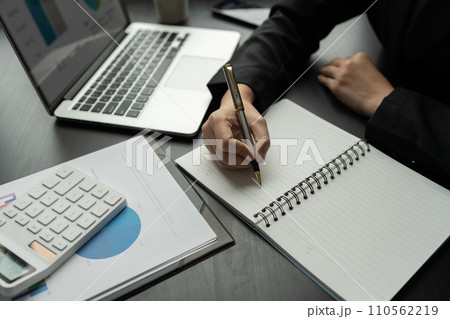 Asian business woman Calculate report with calculator. Take note. Have notepad to remember to do financial report or profit. Asian business woman Calculate report with calculator. Take note. Have notepad to remember to do financial report or profit. 110562219