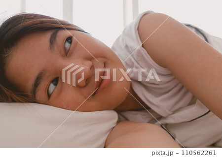 Close up of lazy Asian woman just wake up but not get up from the bed. 110562261