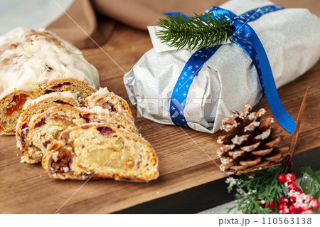 Christmas stollen on wooden cutting board close up Christmas stollen on wooden cutting board close up 110563138