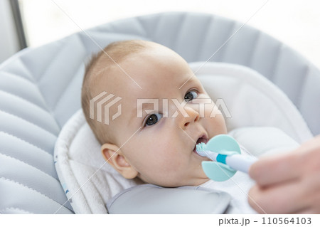 Newborn baby suffering of his tooth growth, mom using a teether to ease the pain, healthcare concept 110564103
