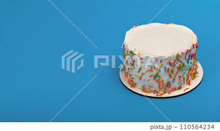 White bento cake, mini dessert decorated with colorful sprinkles, blue banner background 110564234