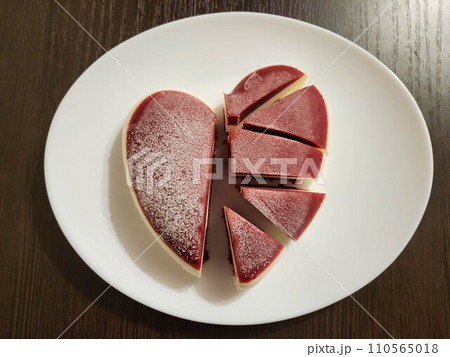 Mousse cut cake in the shape of a heart on a white plate. The concept of Valentine's Day, mother's day, birthday, celebration concept. 110565018