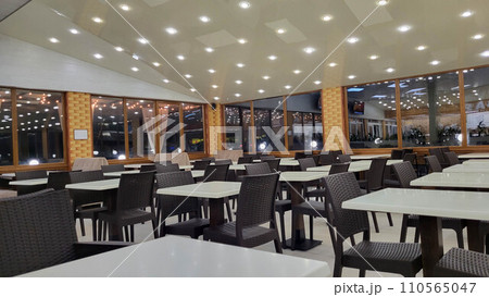 White empty tables with brown chairs in a cafe in the evening. 110565047