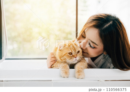 Solitude and smiles in the bathroom, An attractive woman shares her bathtub with her Scottish Fold cat, creating a heartwarming scene of pet love and relaxation. Solitude and smiles in the bathroom, An attractive woman shares her bathtub with her Scottish Fold cat, creating a heartwarming scene of pet love and relaxation. 110566375