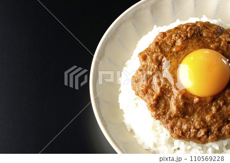 卵黄乗せキーマカレーを黒背景で俯瞰撮影 110569228