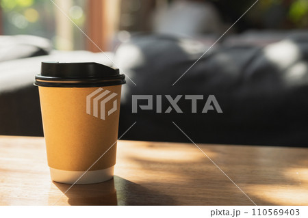 Take away cup of coffee on wooden table.	 110569403