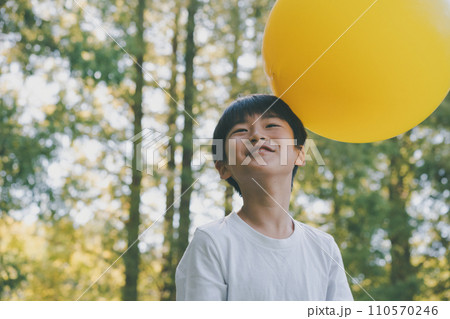 公園で黄色い風船で遊ぶ子供 110570246