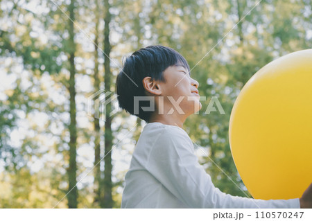 公園で黄色い風船で遊ぶ子供 110570247