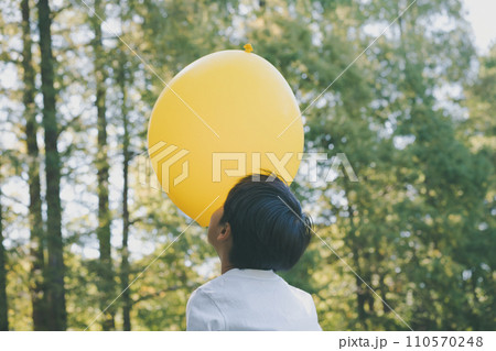 公園で黄色い風船で遊ぶ子供 110570248