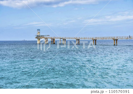 ブセナ海中公園の白い砂浜と青い海　海中展望塔と橋　沖縄県名護市 110570391