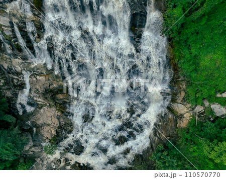 Aerial view waterfall in lush tropical green forest. Nature landscape. Mae Ya Waterfall is situated in Doi Inthanon National Park, Chiang Mai, Thailand. Waterfall flows through jungle on mountainside. Aerial view waterfall in lush tropical green forest. Nature landscape. Mae Ya Waterfall is situated in Doi Inthanon National Park, Chiang Mai, Thailand. Waterfall flows through jungle on mountainside. 110570770