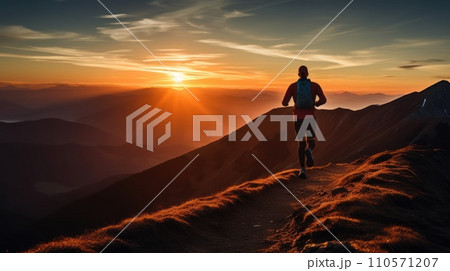 Young man runs on mountain ridge at sunrise 110571207