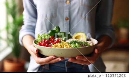 A woman in a t-shirt and jeans standing and holding a vegan food A woman in a t-shirt and jeans standing and holding a vegan food 110571298