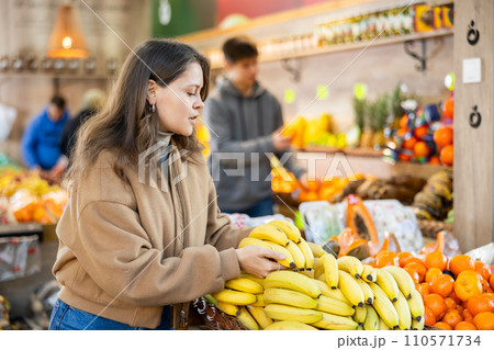 Young woman choosing bananas in vegetable shop 110571734